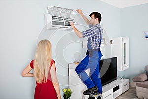 Technician Repairing Air Conditioner At Home