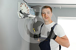 Technician repairing air conditioner on the wall