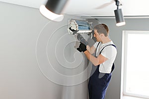 Technician repairing air conditioner on the wall