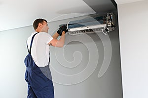 Technician repairing air conditioner on the wall