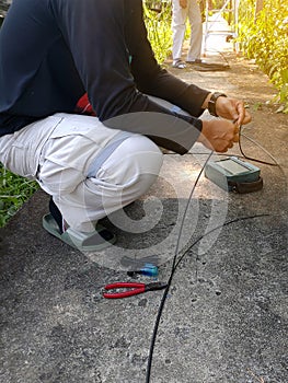 Technician repairing broken fiber optic cable outdoors on site