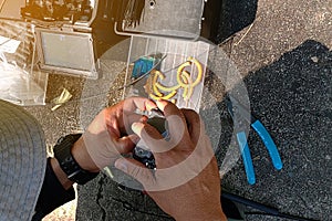 Technician repairing broken fiber optic cable outdoors on site