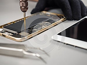 Technician repairing broken smartphone on desk