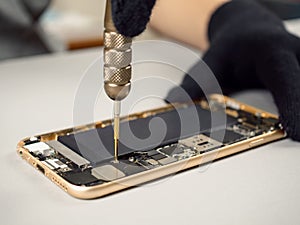 Technician repairing broken smartphone on desk