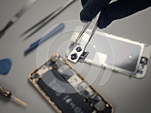 Technician repairing broken smartphone on desk