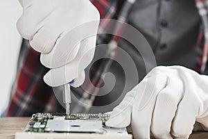 technician repairing computer motherboard with screwdriver. High quality photo