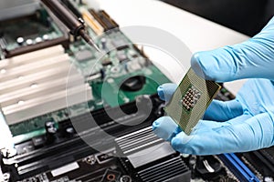 Technician repairing computer motherboard at table, closeup. Electronic device