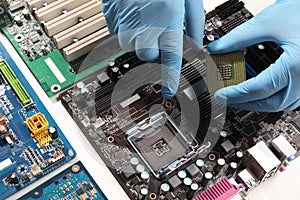 Technician repairing computer motherboard at table, closeup. Electronic device