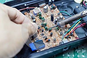Technician repairing electronic of the computer`s circuit board by soldering Irons