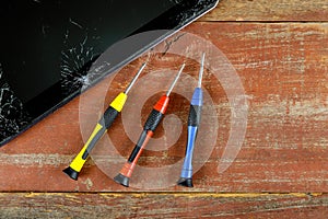 Technician repairing inside of tablet by screwdriver in the mobile phone electronic repairing technology