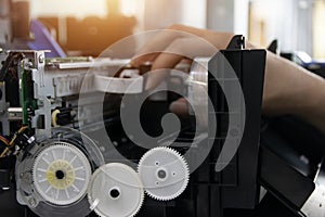 The technician is repairing the printer