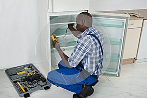 Technician Repairing Refrigerator Appliance