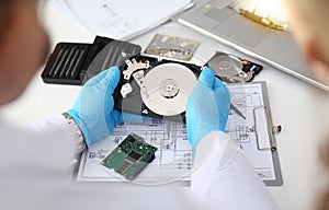 Technician repairs computer hard drive from motherboard