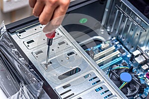 Technician's hand assembling personal computer