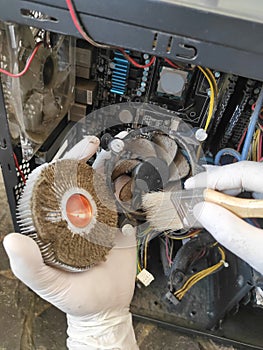 Technicians hand uses a brush to clean the dust of the computer fan stock photo.