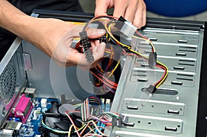 Technician's hands wiring a computer mainboard