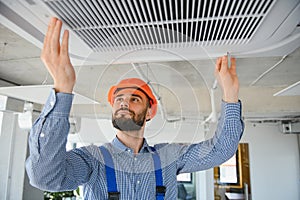 technician service checking and repairing air conditioner indoors