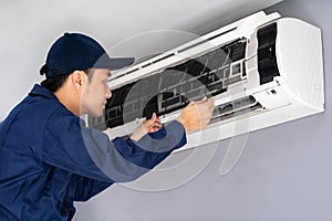 Technician service removing air filter of air conditioner for cleaning