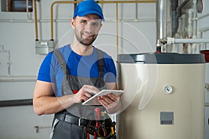 Technician servicing an hot-water heater. Man check equipment of the boiler-house - thermometer.