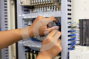 Technician setting  electric control box of machine in factory