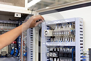 Technician setting  electric control box of machine in factory