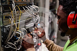 Technician setting up network in server room and wearing ear protection