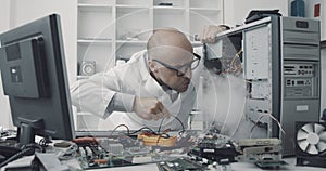 Technician damaging a computer with a screwdriver