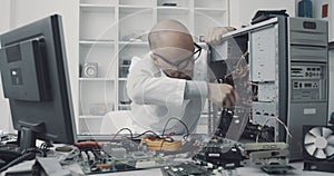 Technician damaging a computer with a screwdriver