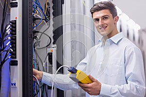 Technician smiling at camera while fixing server