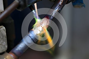 Technician are soldering a coil with copper in order to fix leakage of air compressor. This is a oil and piping problem of air-con