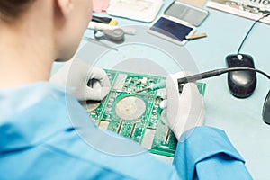 Technician soldering components to a PCB