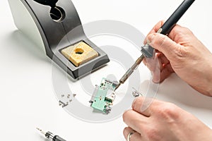 Technician soldering an electronic component with a soldering iron