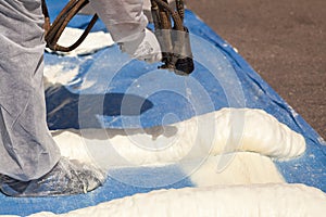 Technician spraying foam insulation using Plural Component Spray Gun.