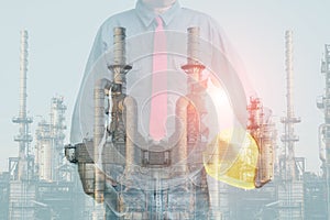 Technician stand hand holding safety helmet with blueprint on petrochemical.