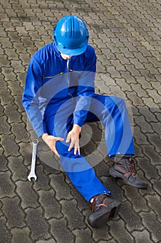 Technician suffering from knee pain on street