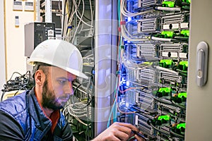 The technician switches the Internet cable of the powerful routers.  A specialist connects the wires in the server room of the