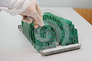 The technician takes a computer board with chips. Spare parts and components for computer equipment. Production of