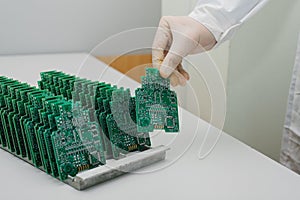 The technician takes a computer board with chips. Spare parts and components for computer equipment. Production of