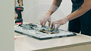 Technician taking monitor display details off at electronics workshop