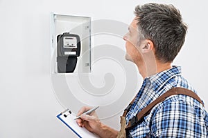 Technician taking reading of electric meter