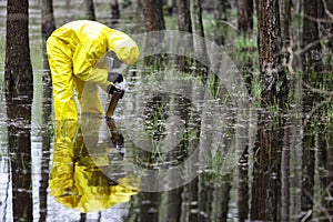 Technician taking sample of water to container in floods contaminated area