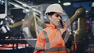 Technician talking smartphone industrial facility close up. Woman engineer phone