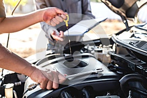 Technician team working of car mechanic in doing auto repair service and maintenance worker repairing vehicle with checking oil,