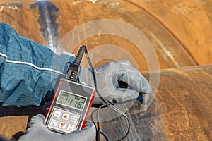 Technician is testing to pipe thickness with ultrasonic test method. Ultrasonic thickness measurement (UTM) photo