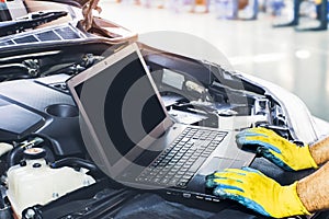 Technician tuning engine car with the computer laptop