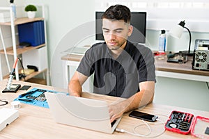 Technician typing on a laptop and installing new software