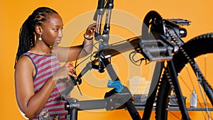 Technician unscrewing bicycle handlebars in atelier shop studio background