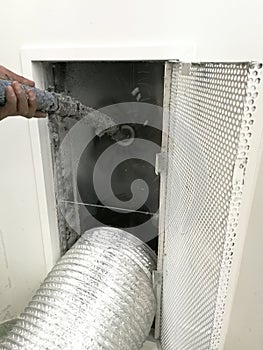 Technician use a vacuum and brush to clean air ducts.