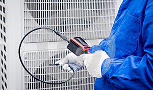 the technician uses a digital camera to check the clogging of the heat exchanger