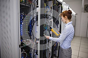Technician using digital cable analyzer on server